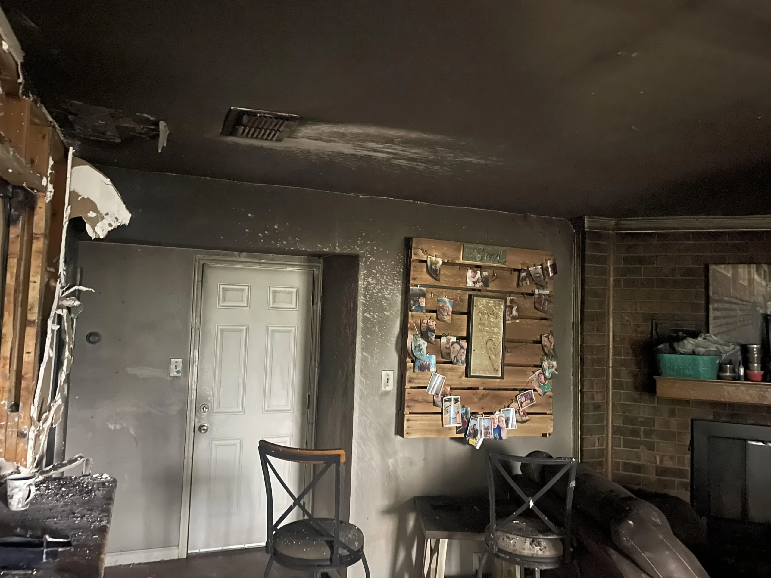 Fire-damaged living room with exposed brick before restoration by Mr. Restore in Frisco, TX